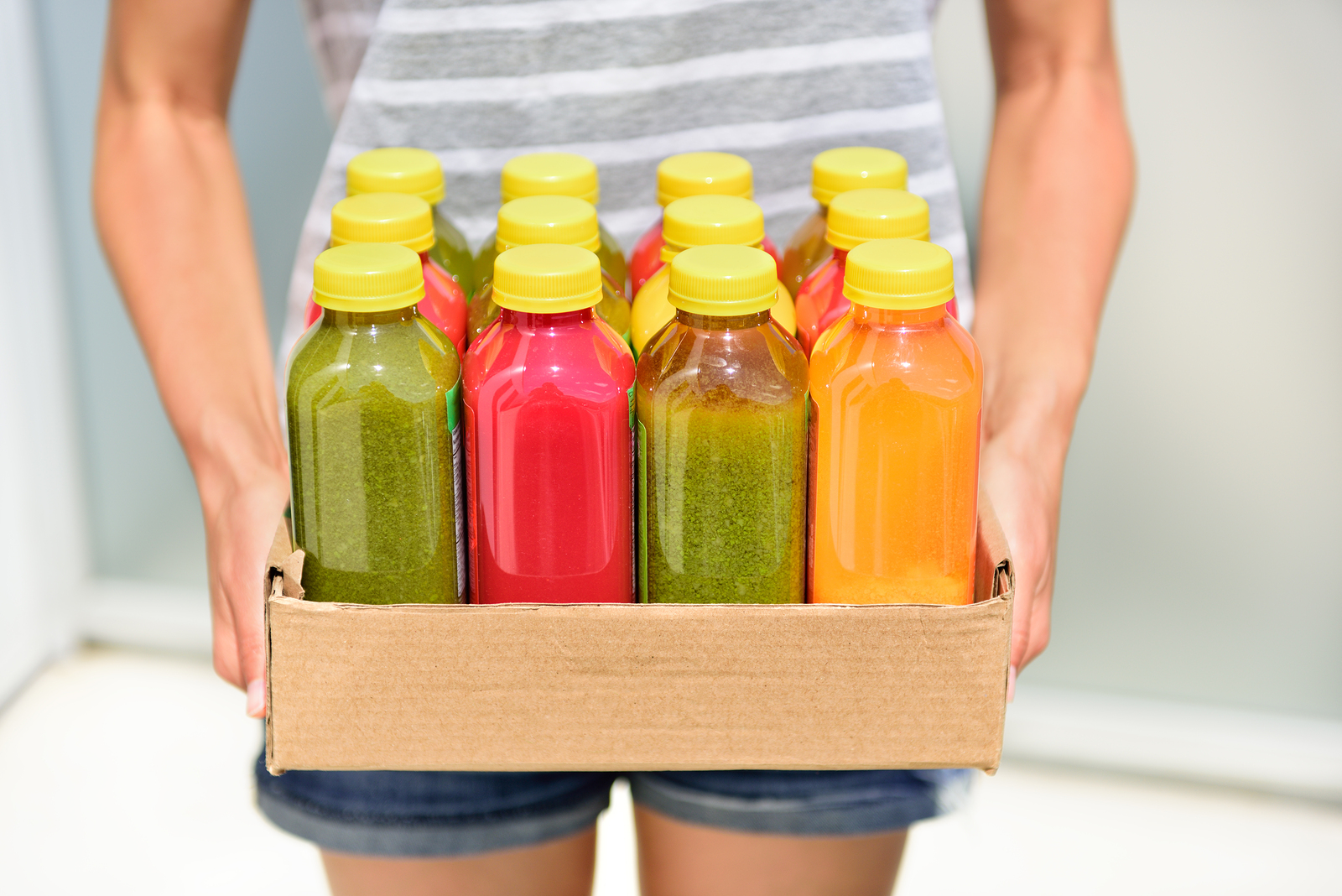 Juicing cold pressed vegetable juices for a detox diet. Dieting by cleansing your body from toxins with raw organic fruits and vegetables juice made fresh and delivered in bottles.